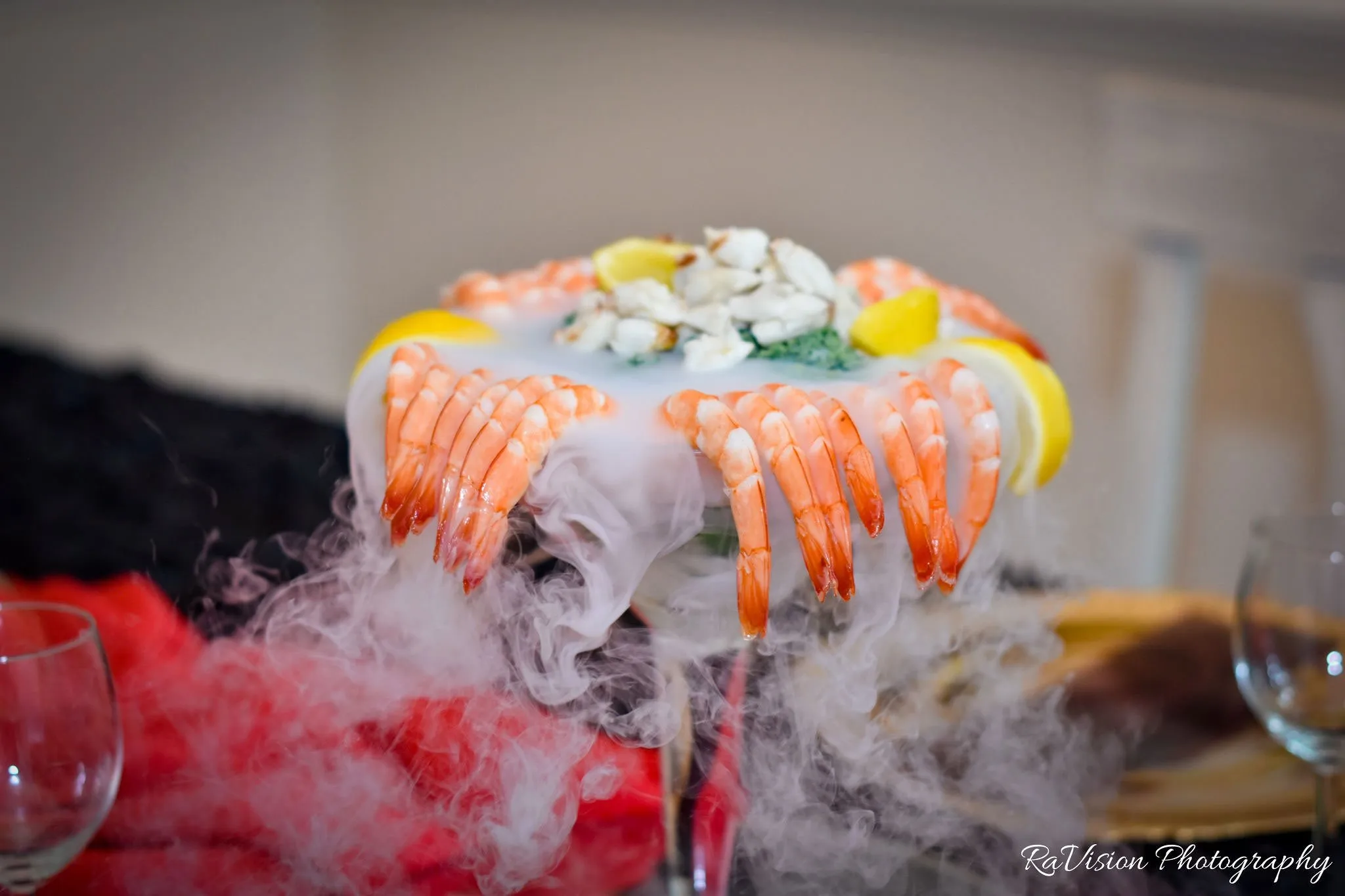 Chilled shrimp and lemon wedges around a seafood platter, with dry-ice fog rolling across the table